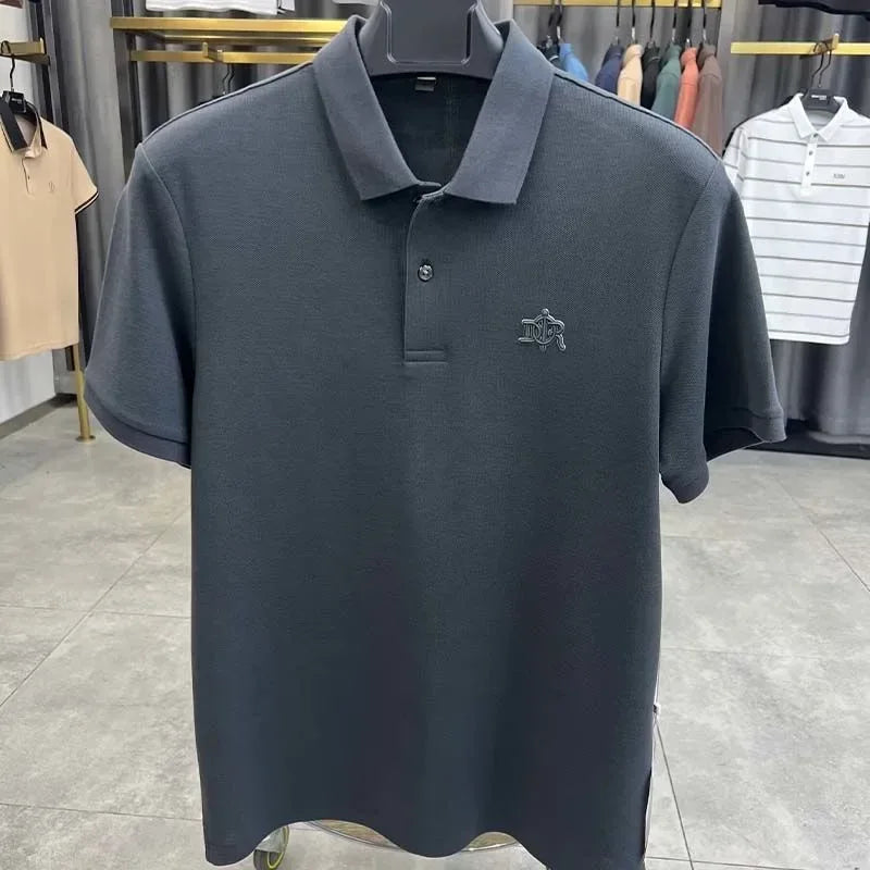 Dark gray polo shirt with a logo on a hanger in a clothing store.
