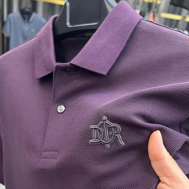 Purple polo shirt with a logo on a hanger