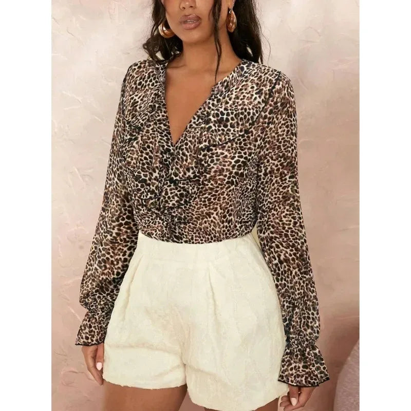 Woman wearing a leopard print top and white shorts against a beige background
