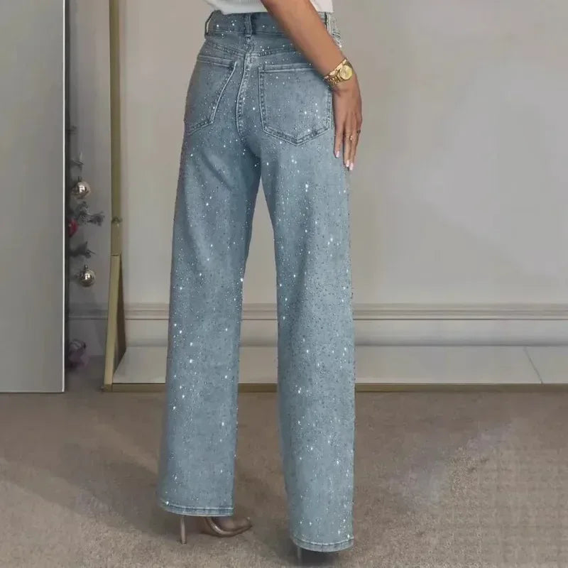 Person wearing sparkly blue jeans in a neutral setting