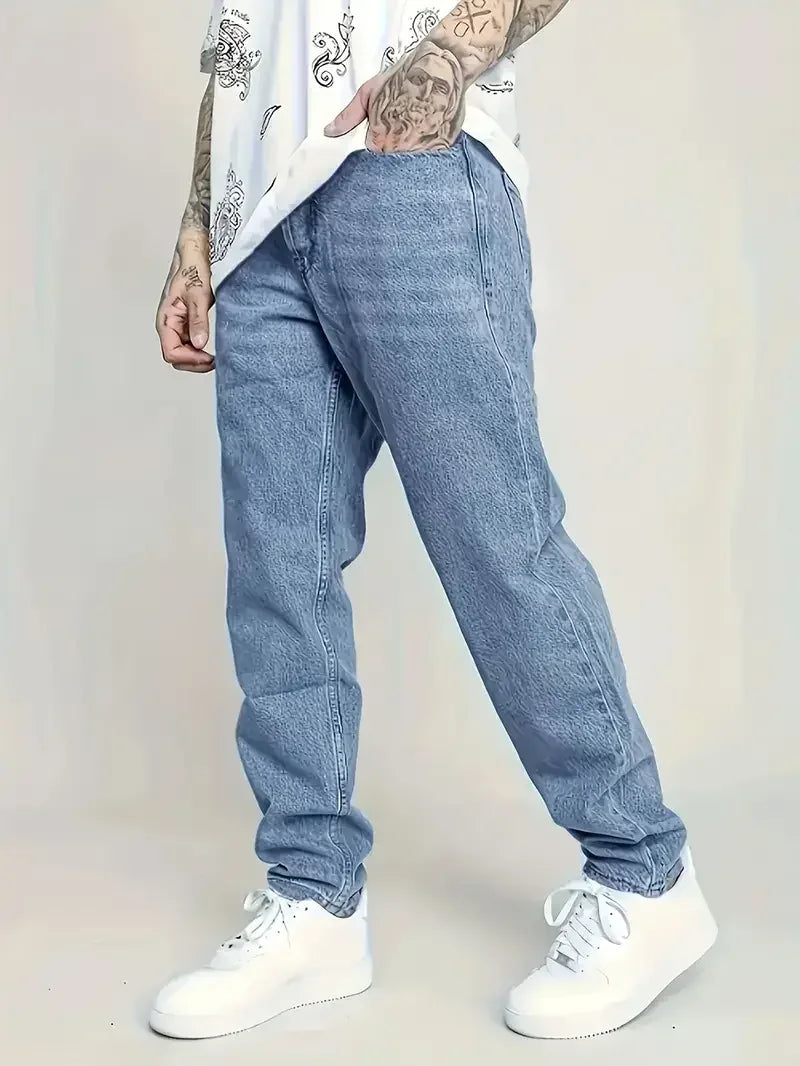 Person wearing blue jeans and white sneakers on a plain background
