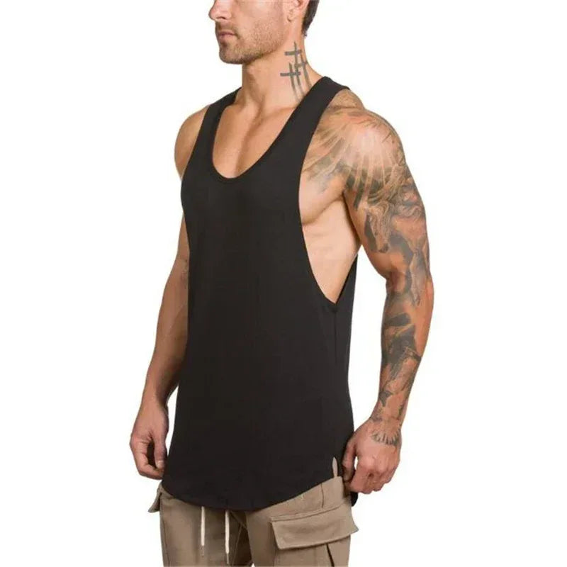 Man wearing a black tank top and beige cargo shorts on a white background