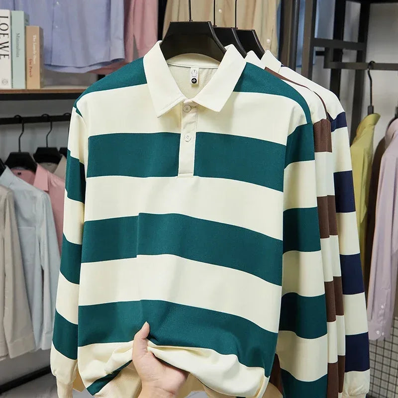 Striped shirt held up in a clothing store with racks of clothes in the background