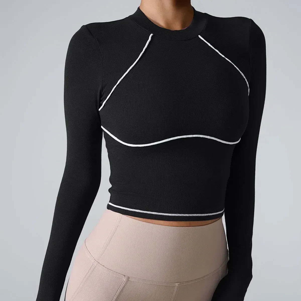 Black long-sleeve top with white accents worn by a person on a gray background