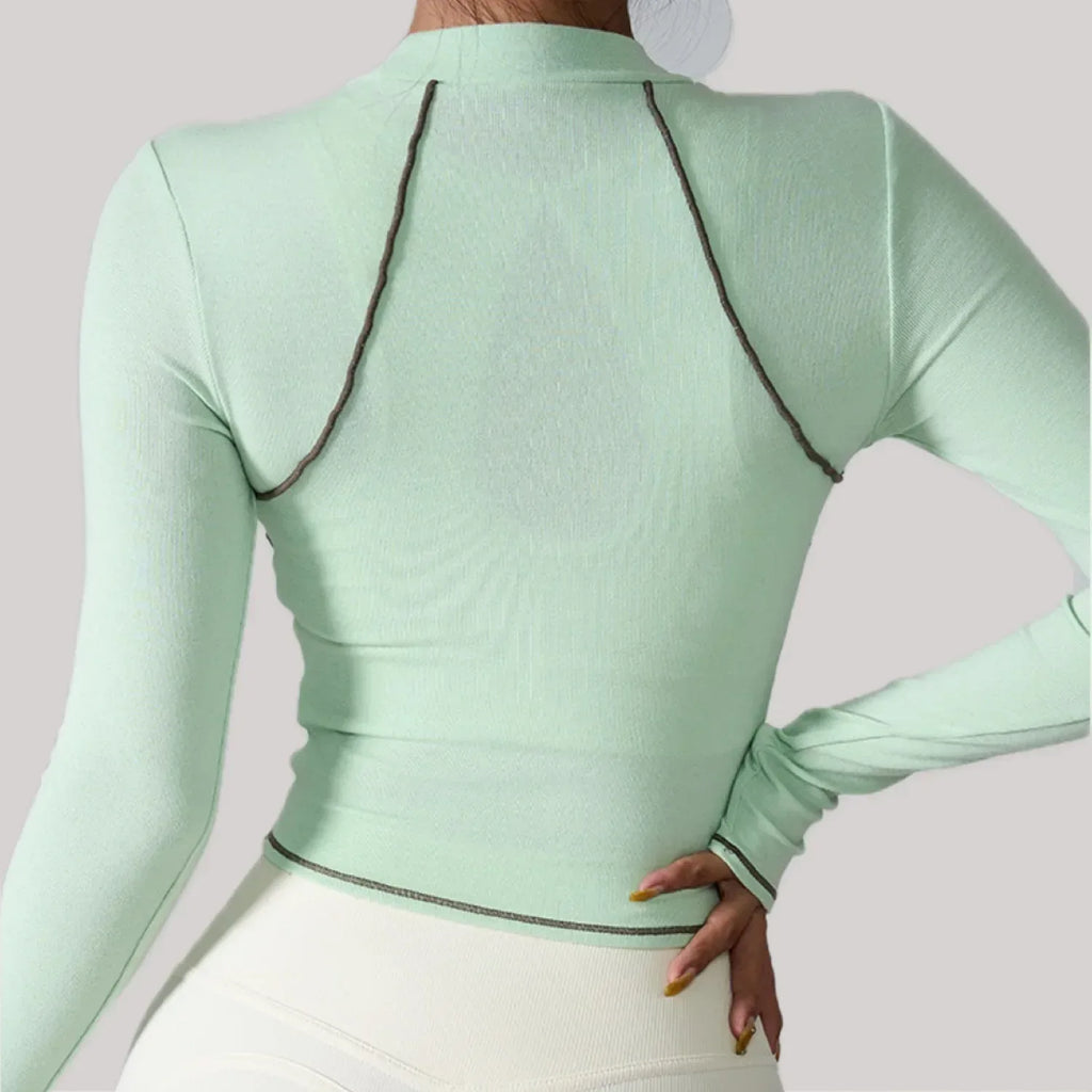 Light green long-sleeve top with black trim on a plain background