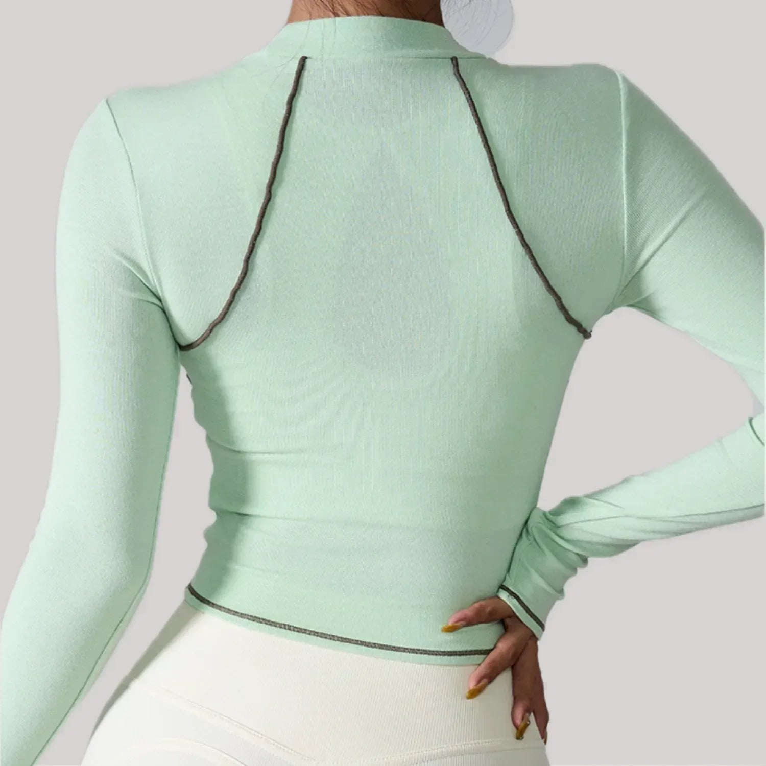 Light green long-sleeve top with black trim on a plain background