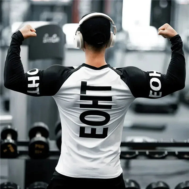 Person flexing muscles in a gym wearing a white and black sports outfit with 'EONE' branding.
