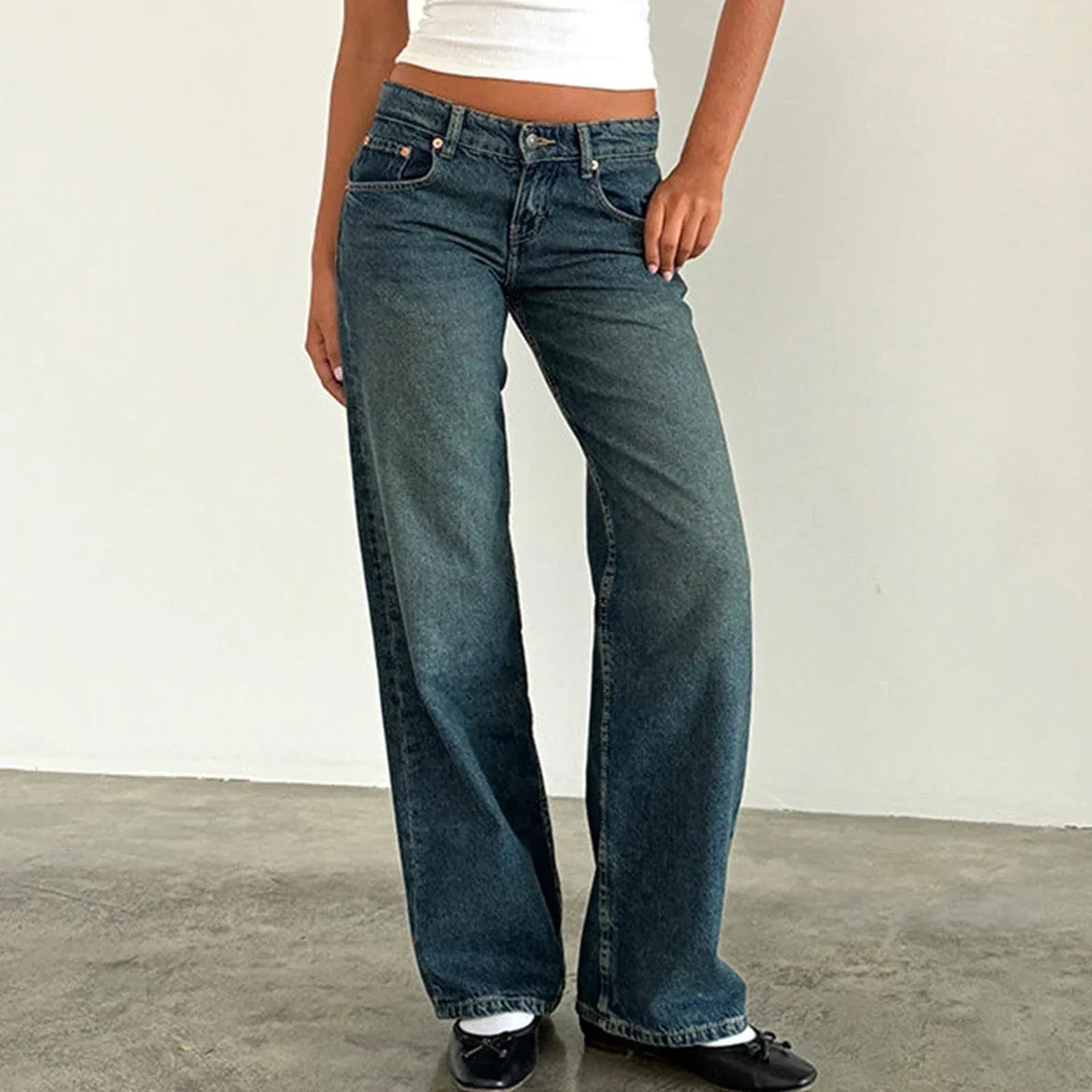 Person wearing blue jeans against a plain background