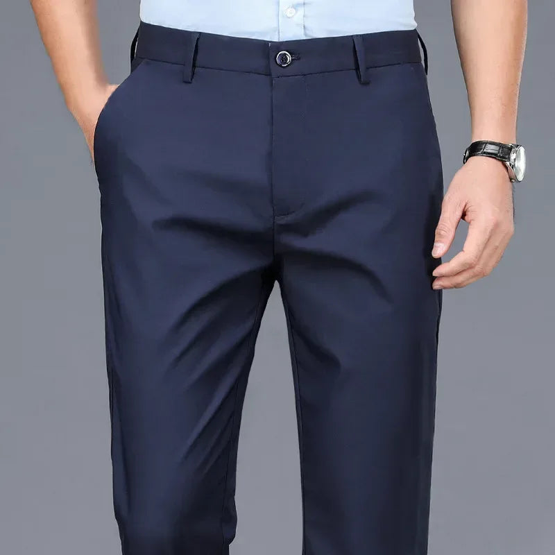 Navy blue dress pants worn by a person on a gray background