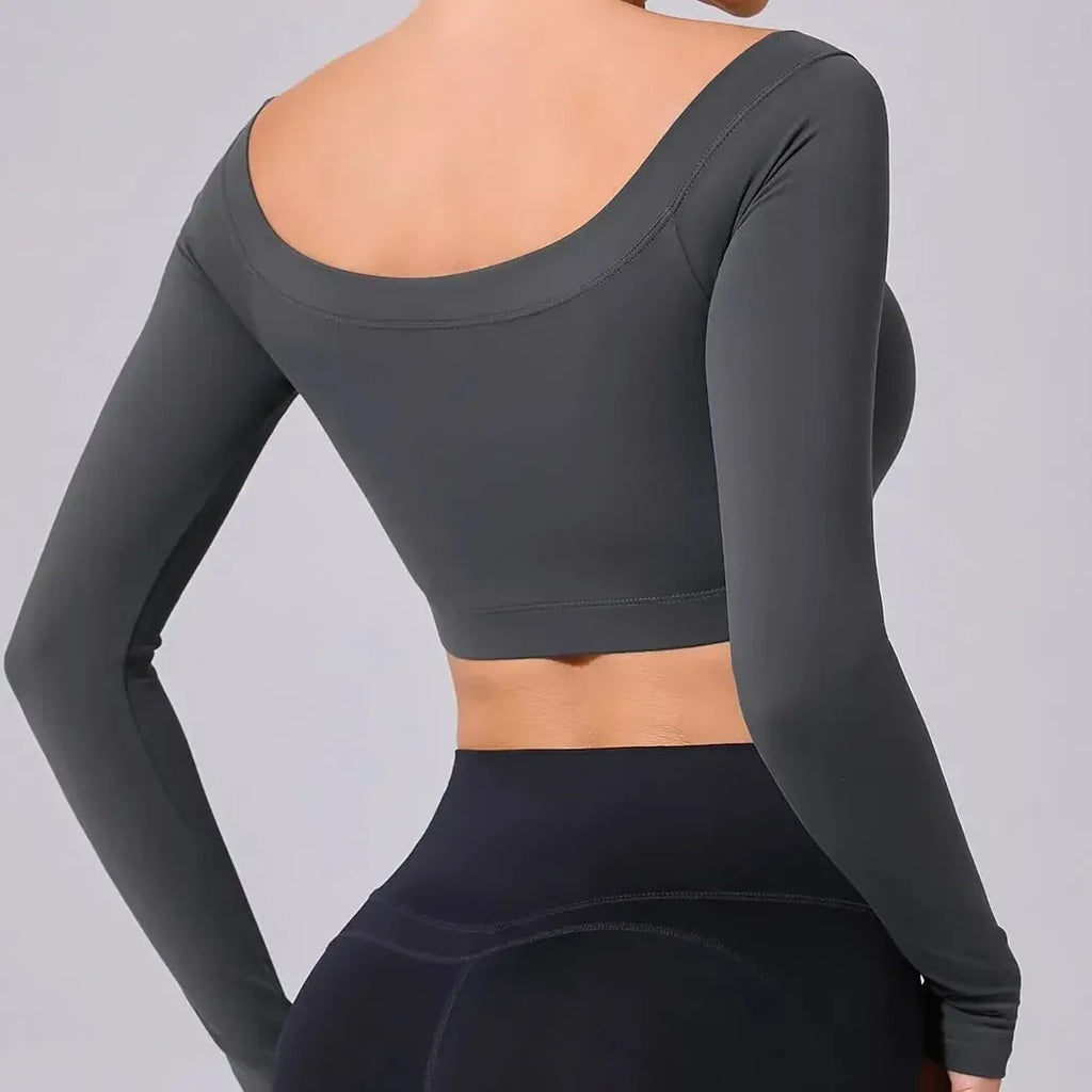 Dark gray long-sleeve athletic top worn by a person on a light gray background