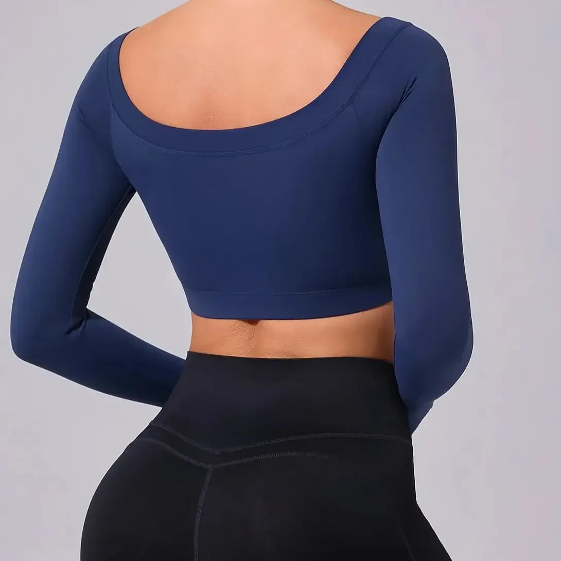 Navy blue long-sleeve crop top worn by a person on a gray background
