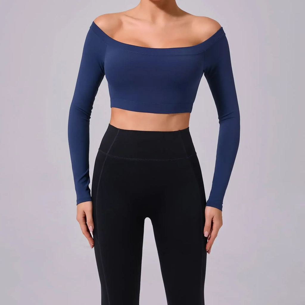 Person wearing a navy blue long-sleeve crop top and black leggings on a gray background