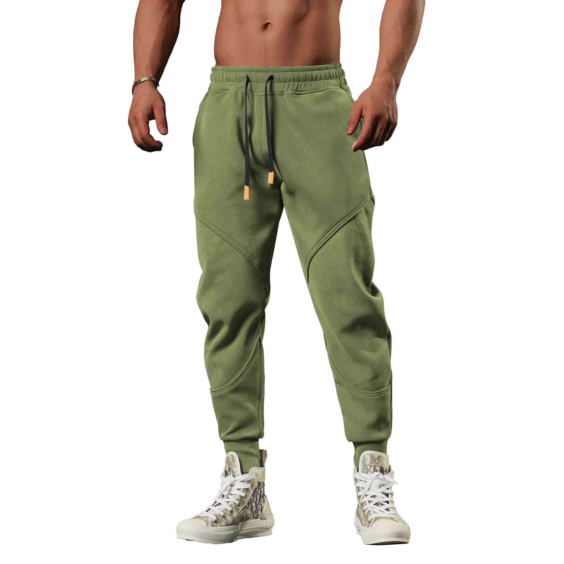 Green jogger pants worn by a person on a white background
