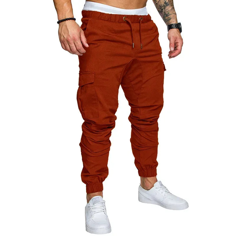 Orange cargo jogger pants worn by a person on a white background