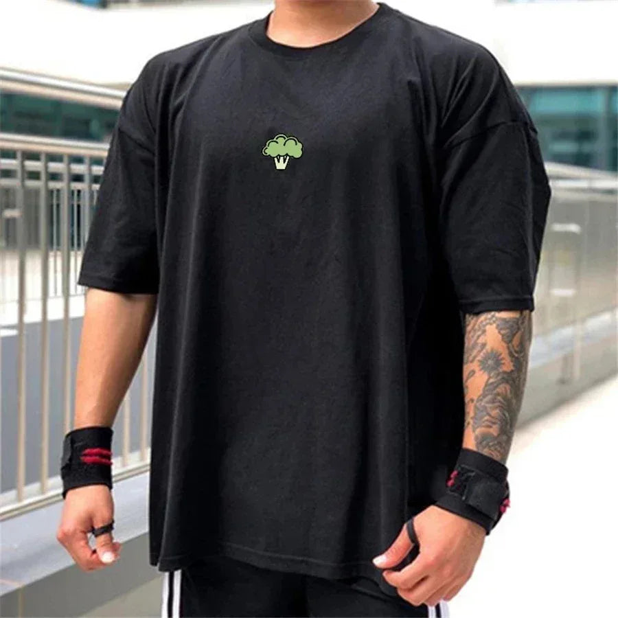 Person wearing a black t-shirt with a green logo, standing outdoors.