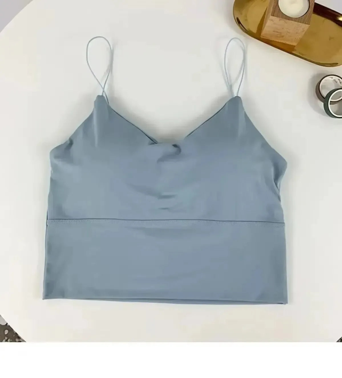 Light blue crop top on a white surface with a minimal background
