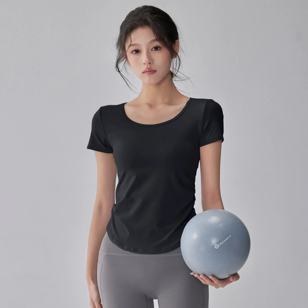 Woman holding a blue exercise ball against a gray background