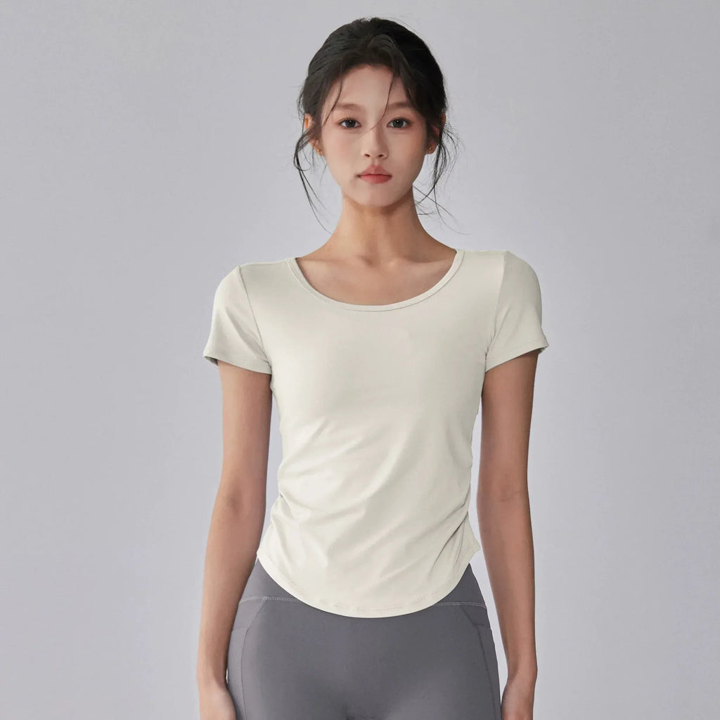Woman wearing a white t-shirt and gray leggings on a gray background