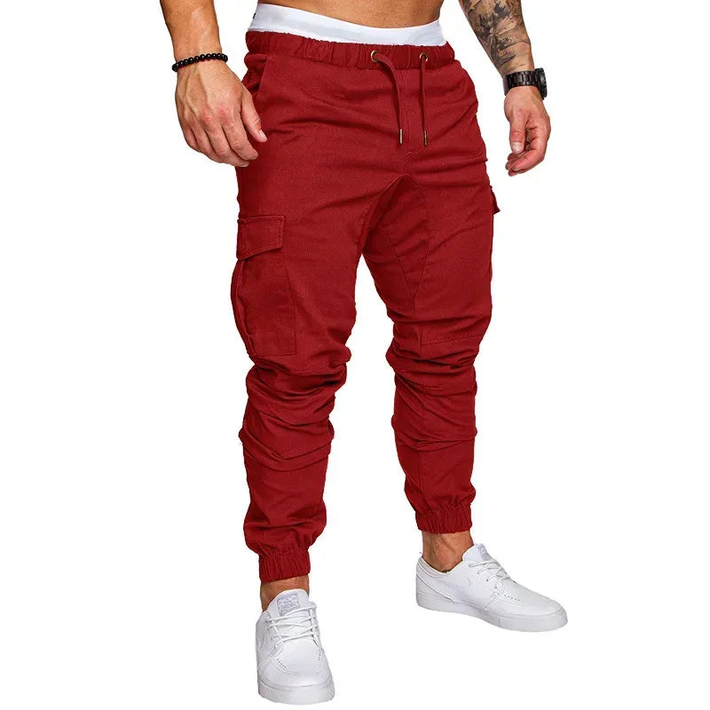 Red cargo jogger pants worn by a person on a white background