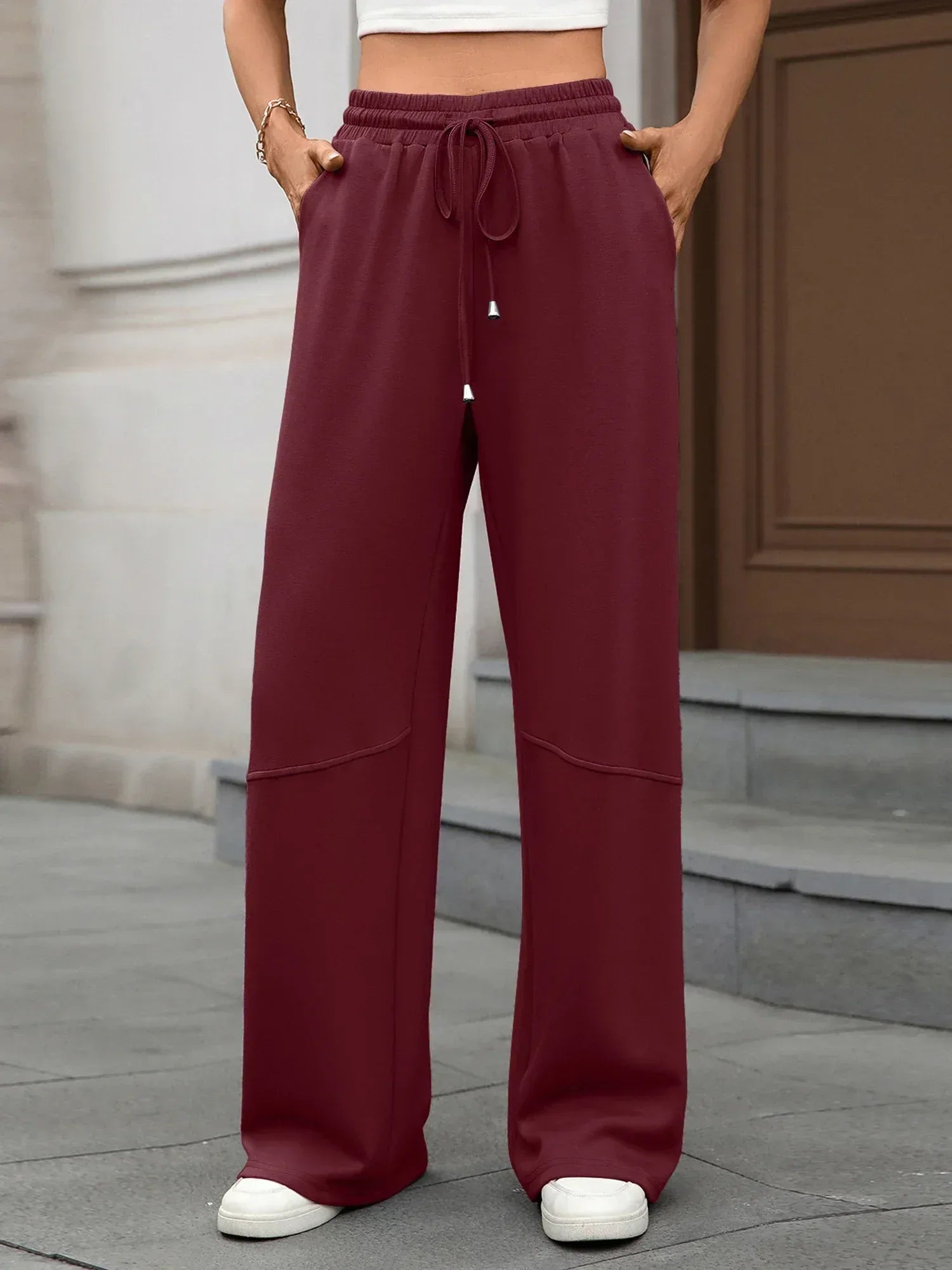 Person wearing maroon wide-leg pants with a neutral background
