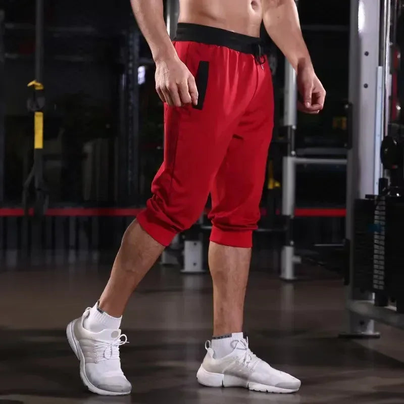 Person wearing red shorts and white sneakers in a gym setting