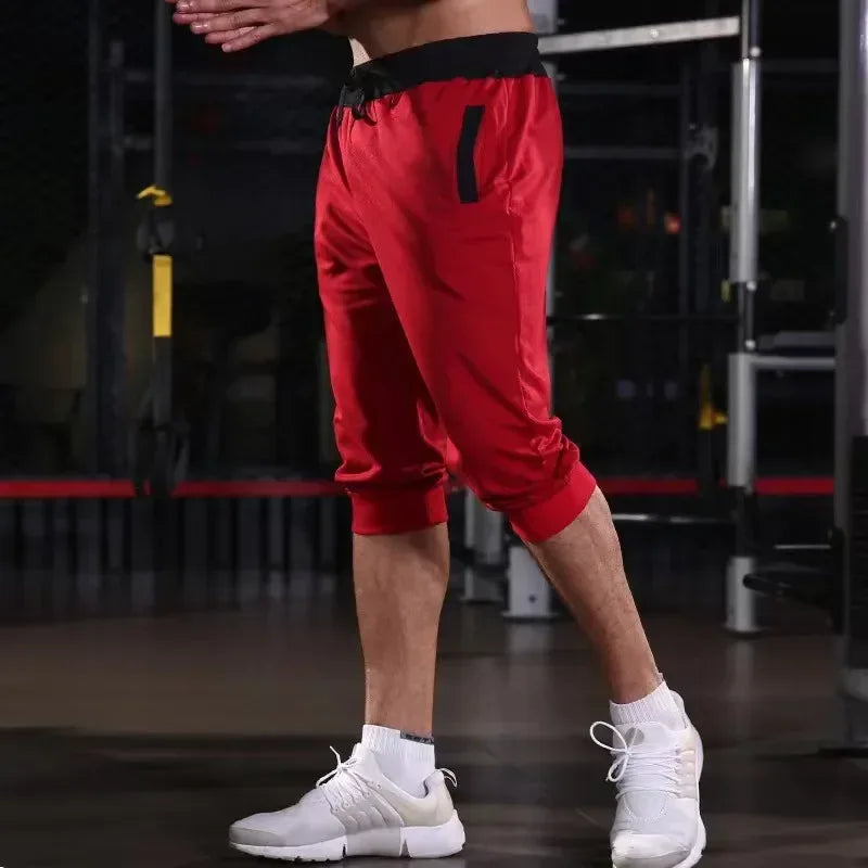 Person wearing red athletic shorts and white sneakers in a gym setting