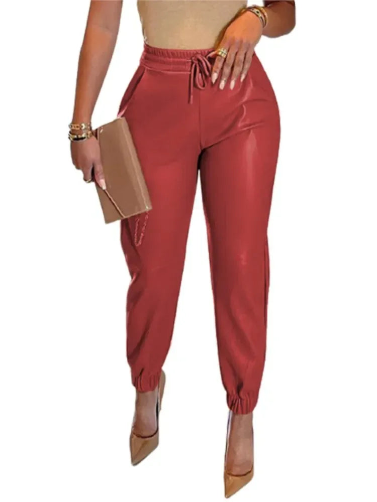 Red jogger pants worn by a person on a white background