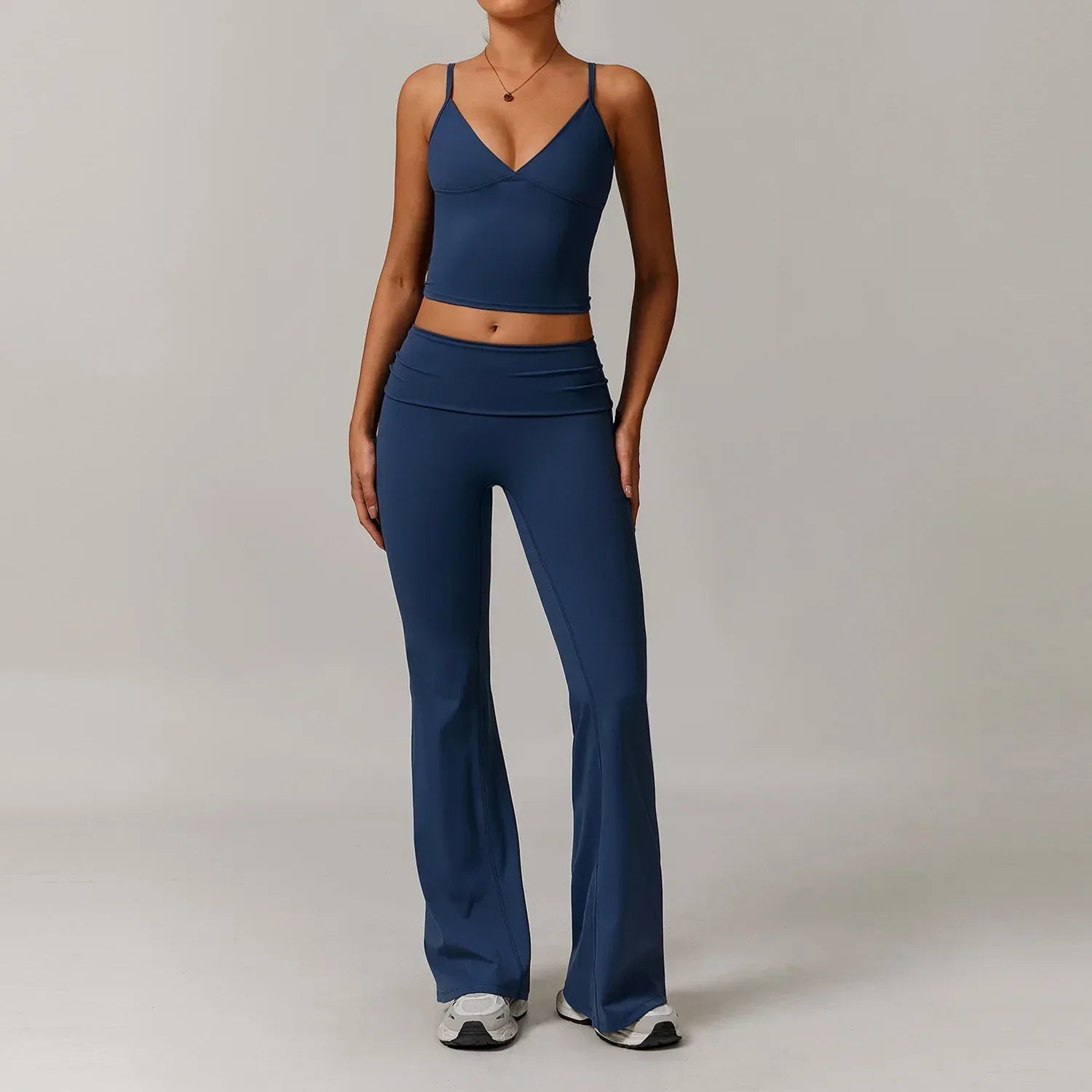 Woman wearing a royal blue v-neck tank top and high waisted wide leg flared leggings for a seamless athleisure yoga outfit. - BetterPlace