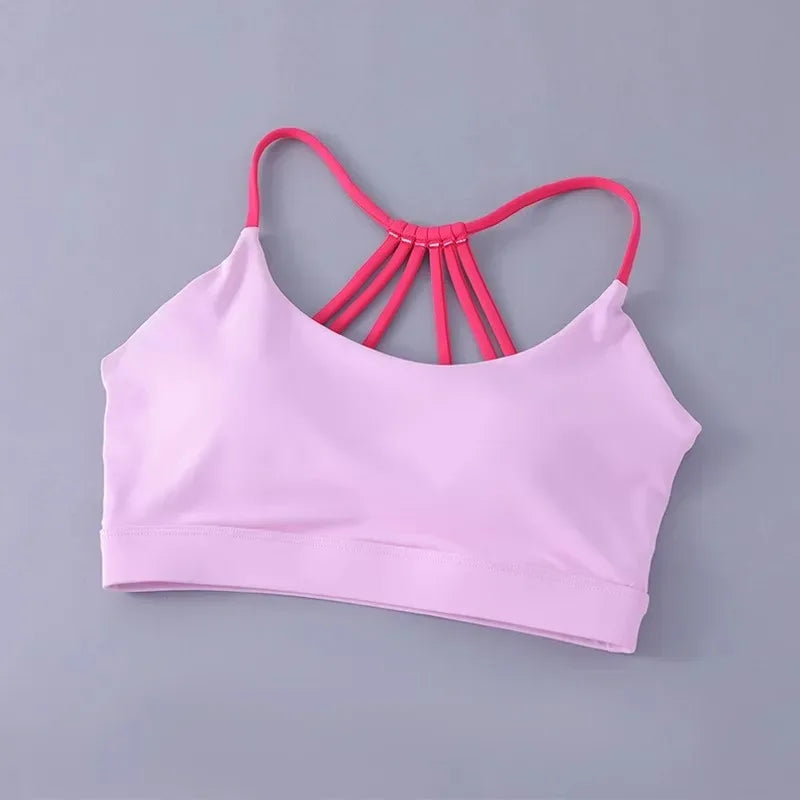 Pink sports bra with red straps on a gray background