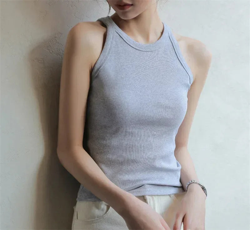 Person wearing a light gray tank top against a neutral background
