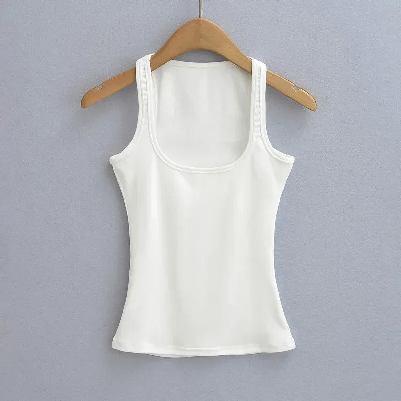 White tank top on a wooden hanger against a gray background