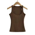 Brown tank top on a wooden hanger against a white background