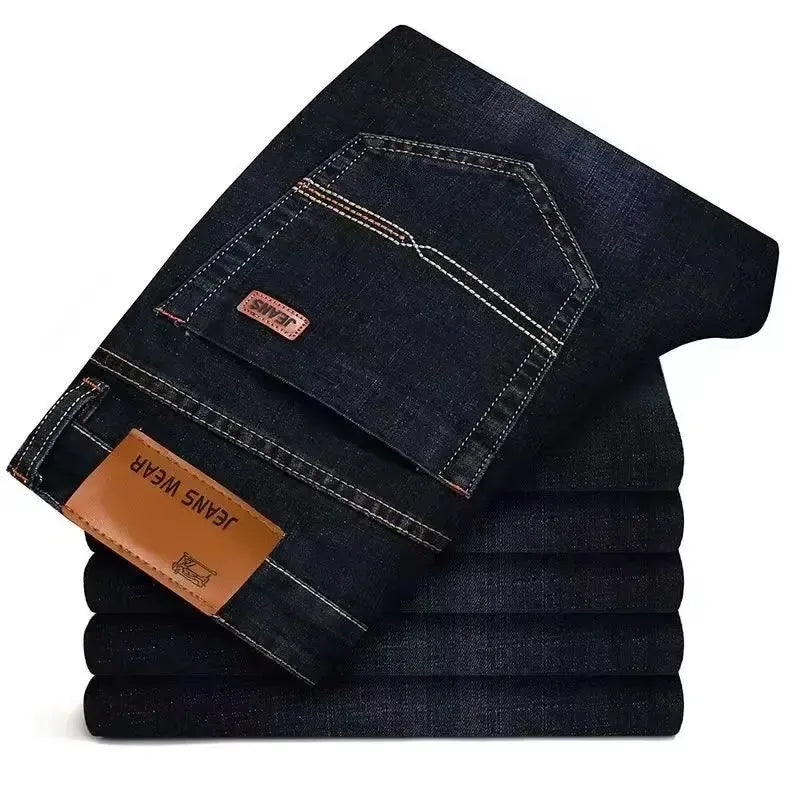 Stack of dark blue jeans with a visible brand label on a white background