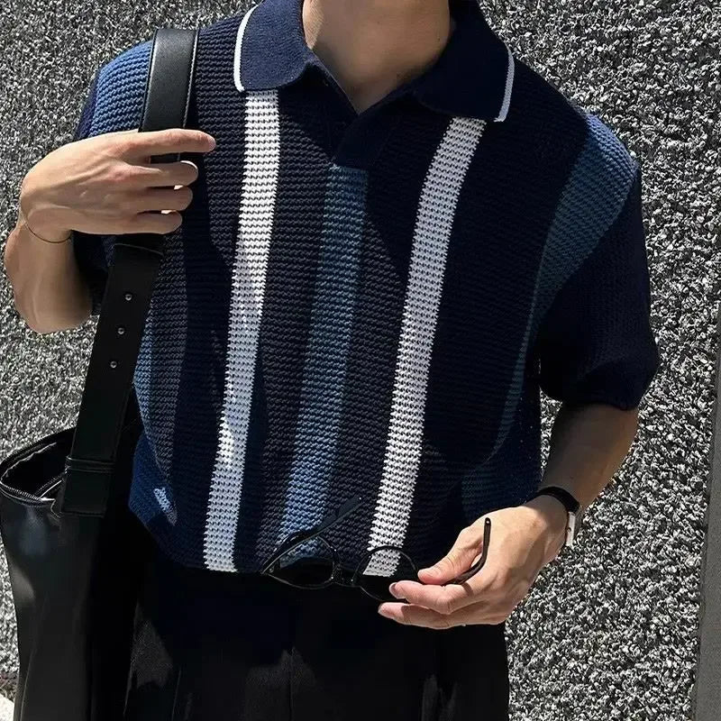 Person wearing a dark blue and white striped shirt against a textured wall.