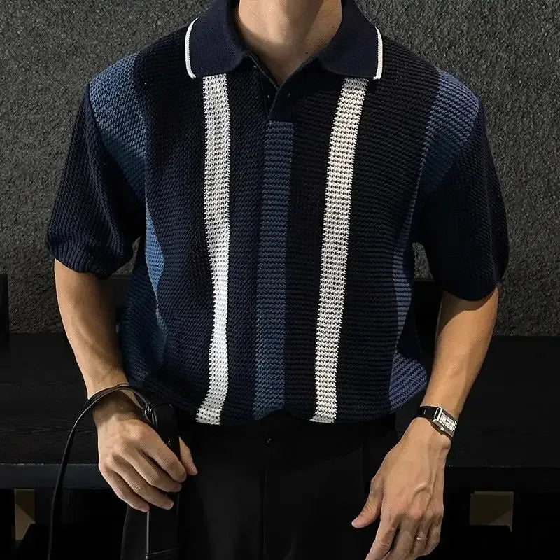 Person wearing a dark blue and white striped polo shirt against a dark background