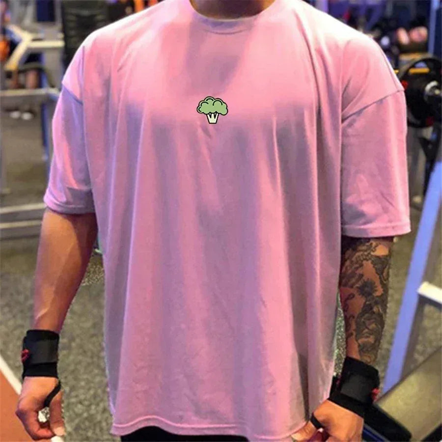 Person wearing a pink t-shirt with a green logo in an indoor setting