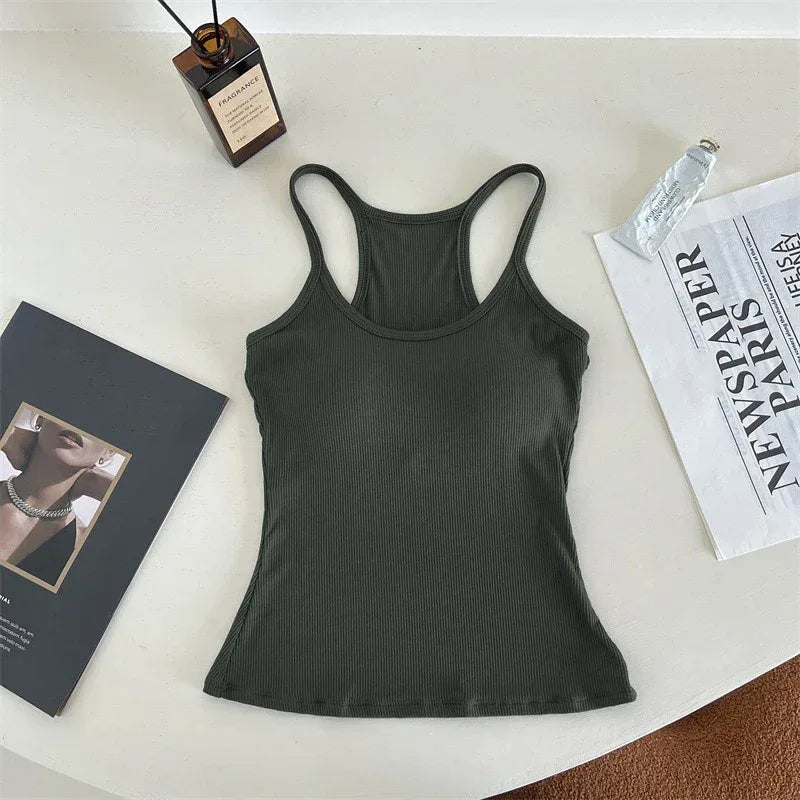 Black tank top on a white surface with a bottle and newspaper.