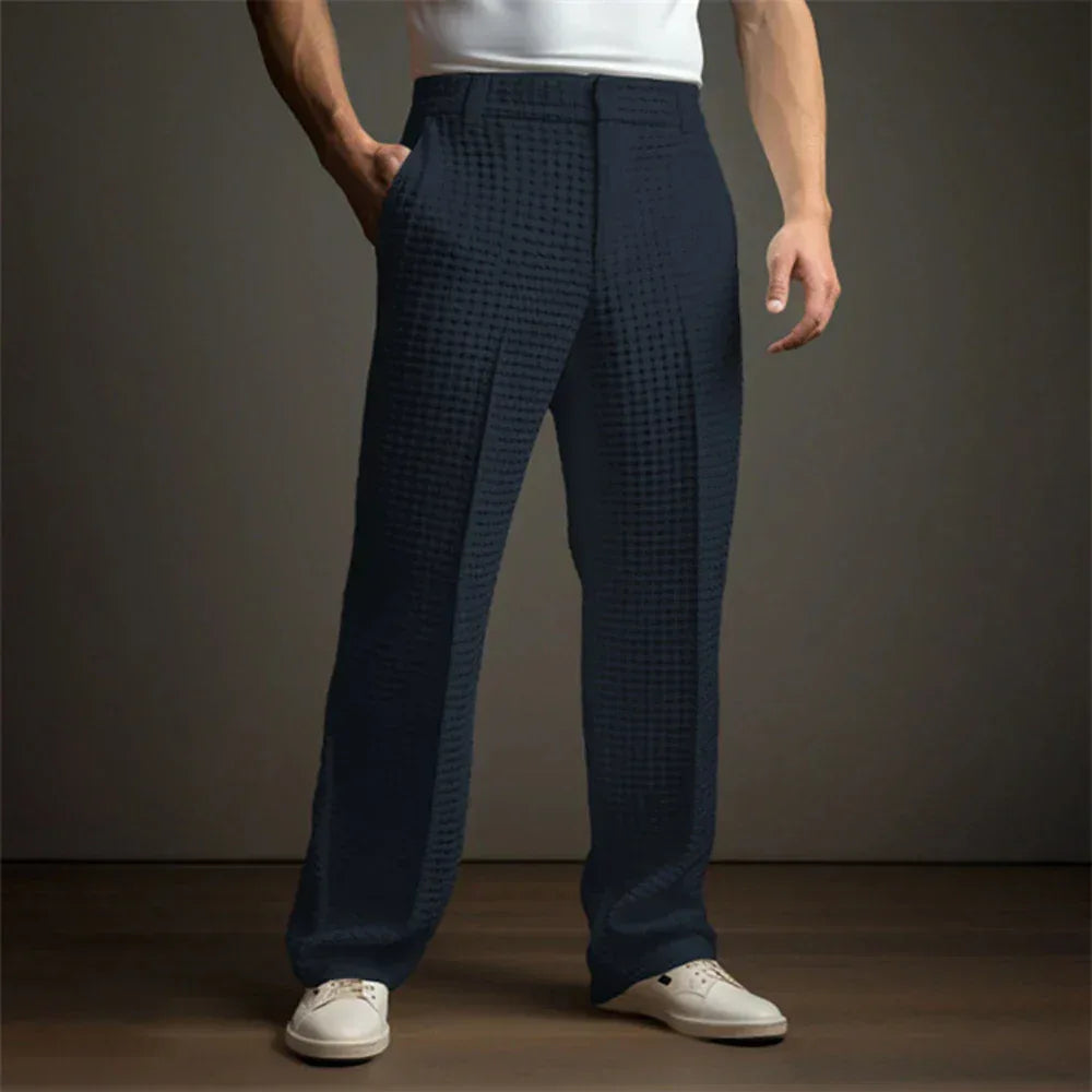 Person wearing navy checkered pants with a plain background