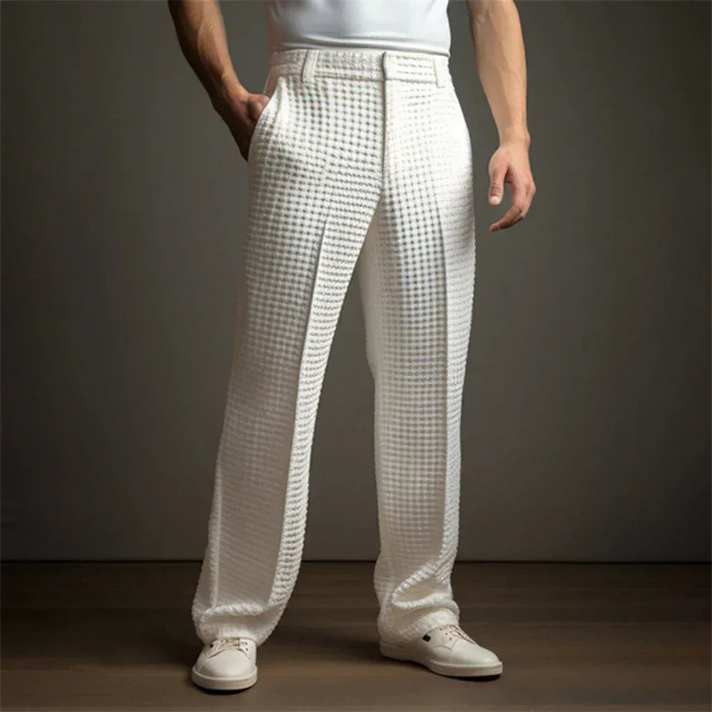 Person wearing white checkered pants and white shoes on a dark background