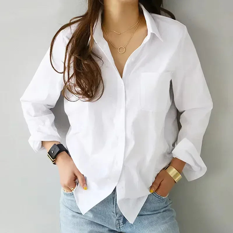 Person wearing a white shirt and jeans with a plain background