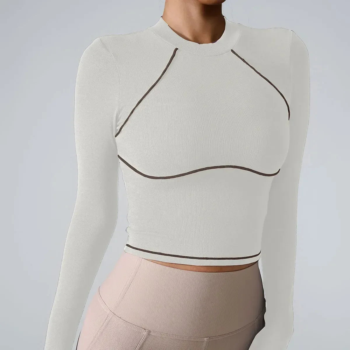 Beige long-sleeve top with black accents on a plain background