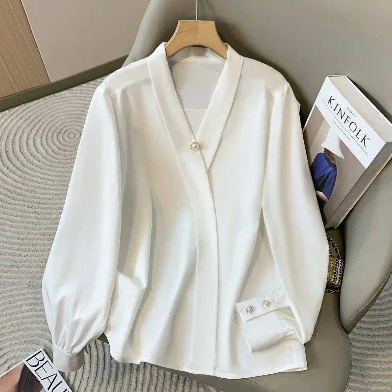 White blouse on a hanger with a book titled 'KINfolk' in the background.