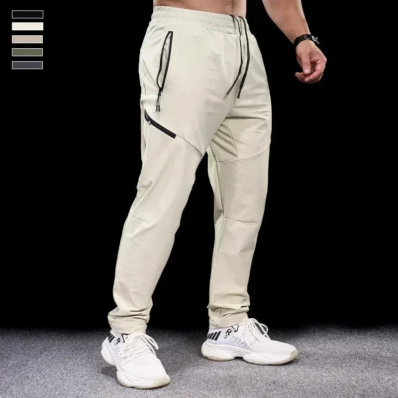 Beige jogger pants worn by a person on a black background
