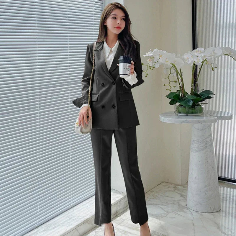 Woman in a black suit holding a coffee cup in an office setting