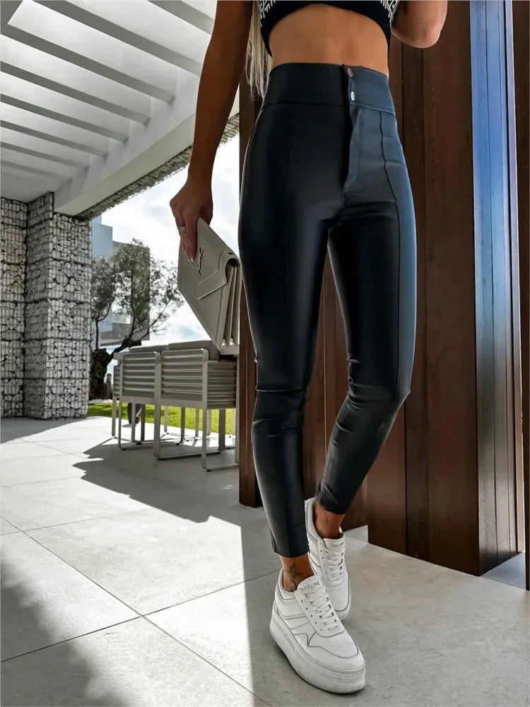 Person wearing black leggings and white sneakers standing on a patio.